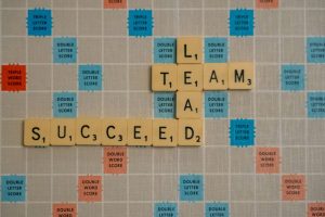 Scrabble board with the words: LEAD, TEAM, SUCCEED.