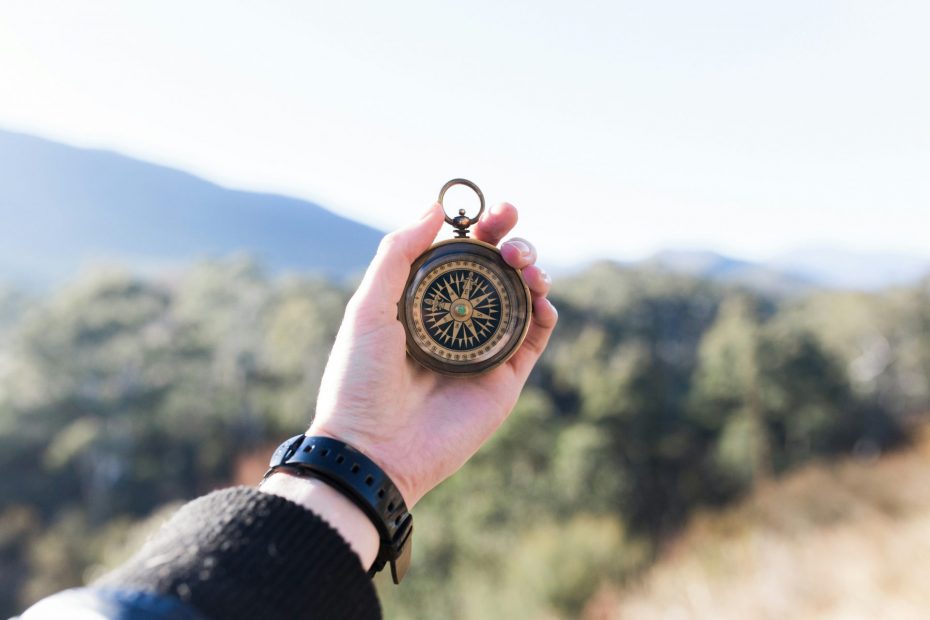 Hiker's hand holding a compass.